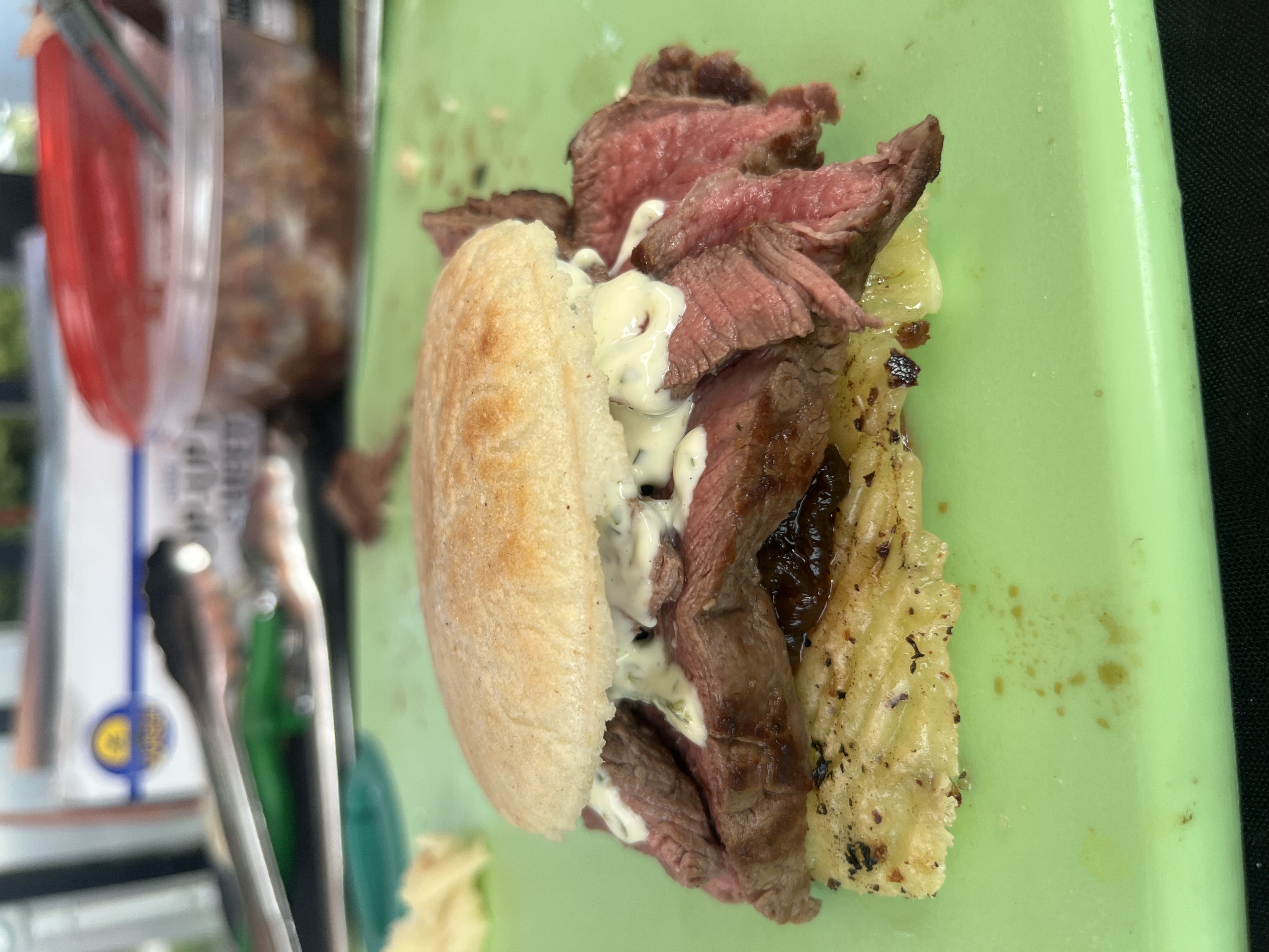 Sliced medium-rare 4oz filet mignon with onion jam, swiss and chimichurri mayonnaise on a griddled arepa